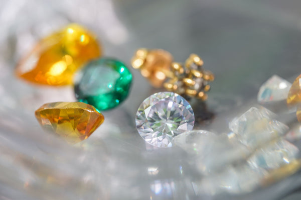 Diamonds in different types of diamond colors, yellow, green, regular diamonds, laying on a table under a magnifier.