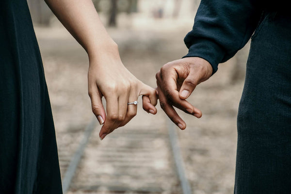 A couple holding hands while one wears a Valentine's Gift Ring on their finger.